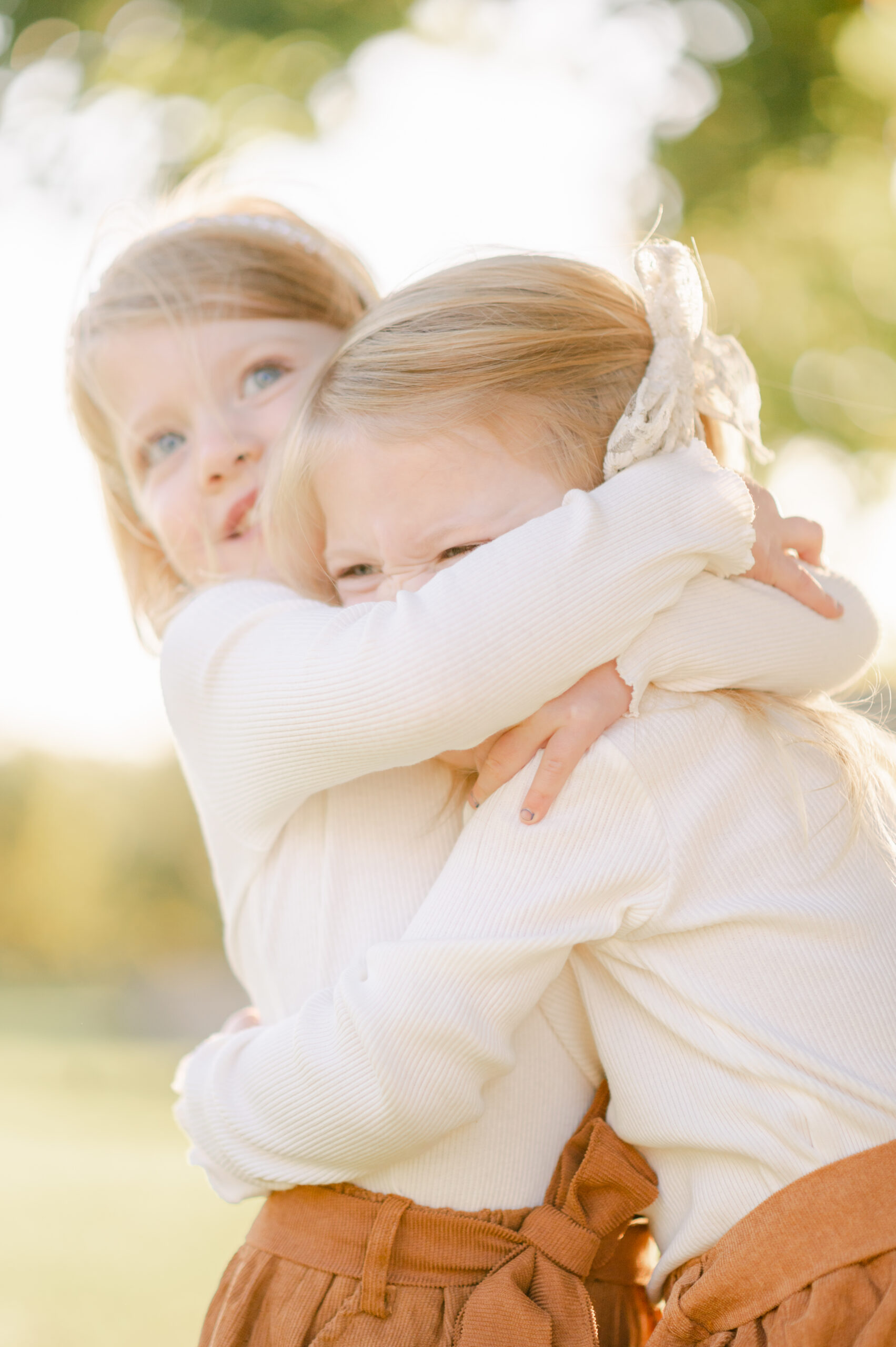 Two twin girls laughing and hugging each other after doing one of the 5 boston kid friendly activities